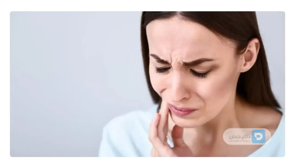خانمی که درد موکوسل دهان دارد و دستش را روی صورتش قرار داده است.
